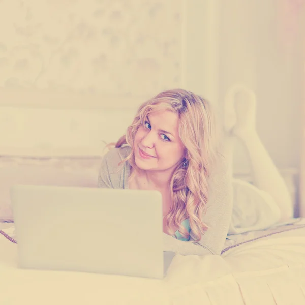 Woman with laptop on bed — Stock Photo, Image