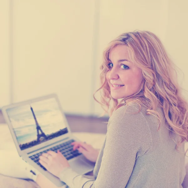 Woman with laptop on bed — Stock Photo, Image