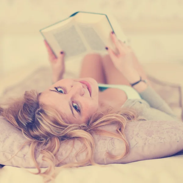 Krásná žena, čtení na posteli — Stock fotografie