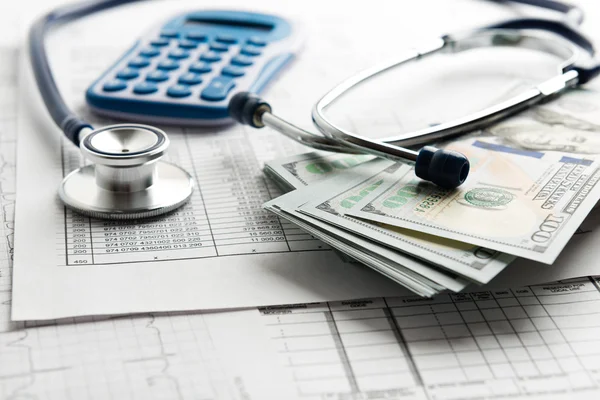 Stethoscope with  banknotes and calculator — Stock Photo, Image