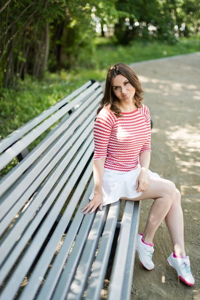 Model sits on a park bench — Stock Photo, Image