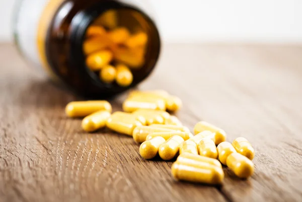 Pills on wooden surface — Stock Photo, Image