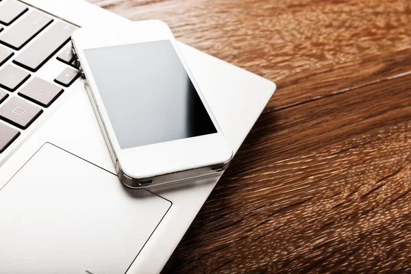 Telefon auf Laptop-Tastatur — Stockfoto