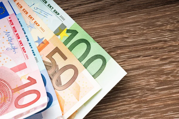 Na drewnianym stole banknotów euro — Zdjęcie stockowe