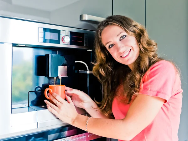 Jovem feliz fazendo xícara de café máquina de cozinha interior — Fotografia de Stock