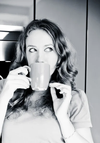 Beautiful happy young woman drinking coffee at home in the morni — Stock Photo, Image