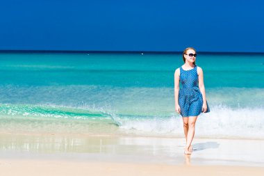 Kumsalda yürüyen genç bir kadın