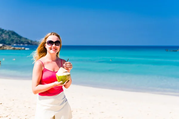 Donna che beve latte di cocco sulla spiaggia — Foto Stock