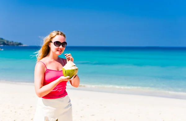 Donna che beve latte di cocco sulla spiaggia — Foto Stock
