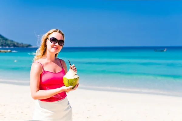 Vrouw drinken kokosmelk op strand — Stockfoto