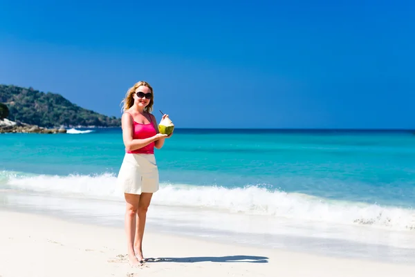 Mulher bebendo leite de coco na praia — Fotografia de Stock