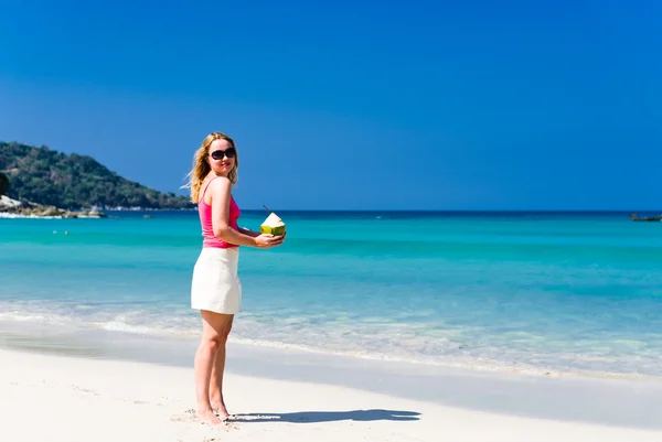 Mulher bebendo leite de coco na praia — Fotografia de Stock