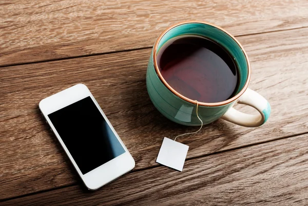 Taza de té y teléfono — Foto de Stock