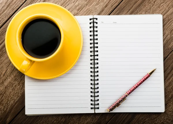 Чашка кофе с ноутбуком и ручкой — стоковое фото
