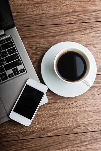 Skrivbord med dator, kaffe, smartphone — Stockfoto