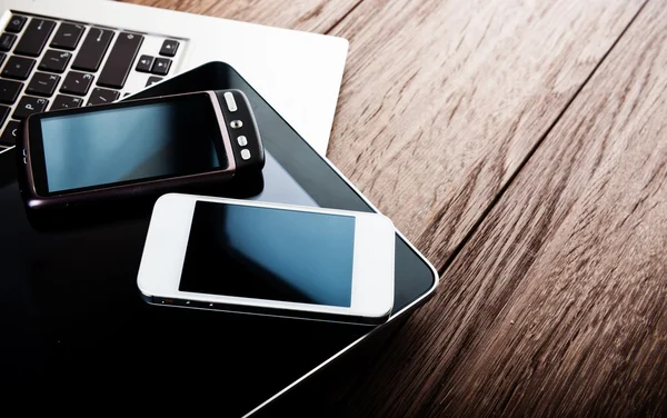 Telefone und Tablet-PC auf dem Schreibtisch — Stockfoto