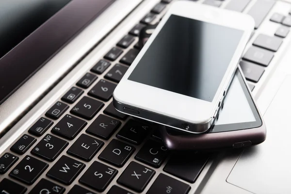 Keyboard with  phones on  desk — Stock Photo, Image