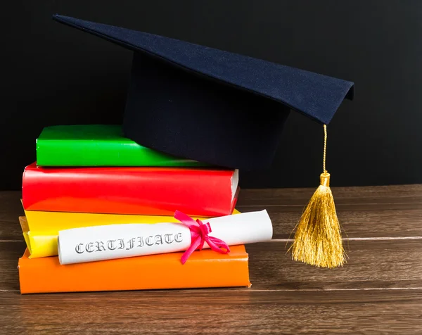 A mortarboard and graduation scroll — Stock Photo, Image