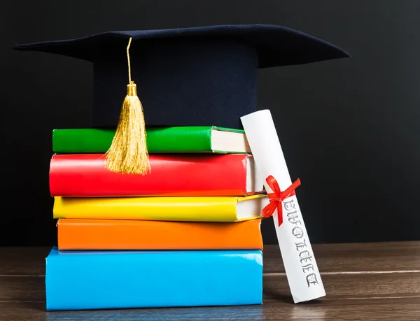 A mortarboard and graduation scroll — Stock Photo, Image