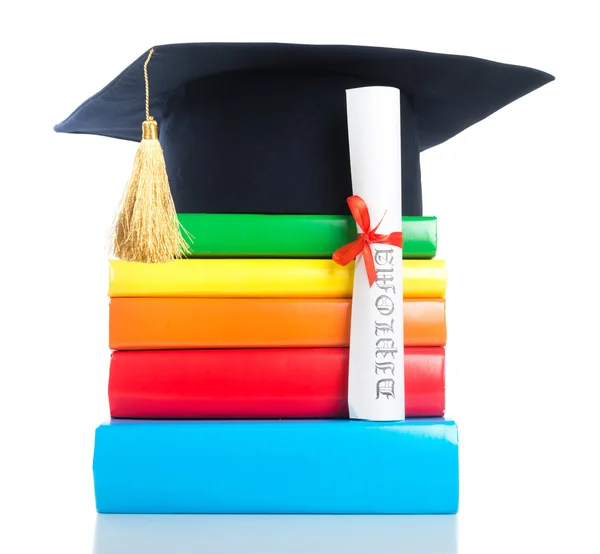 Mortarboard and graduation scroll on books — Stock Photo, Image