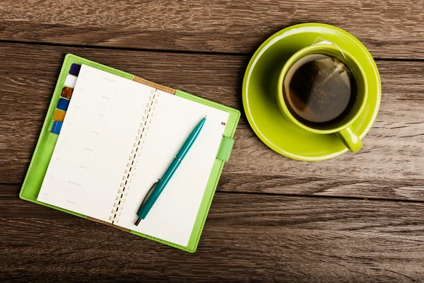 Kopje thee, pen, geopende organisator — Stockfoto