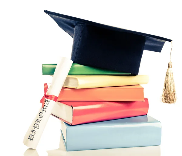 A mortarboard and graduation scroll on books — Stock Photo, Image