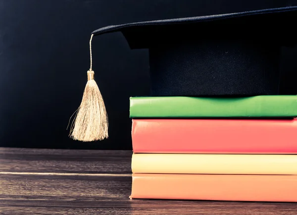 Graduation mortarboard on books — Stock Photo, Image