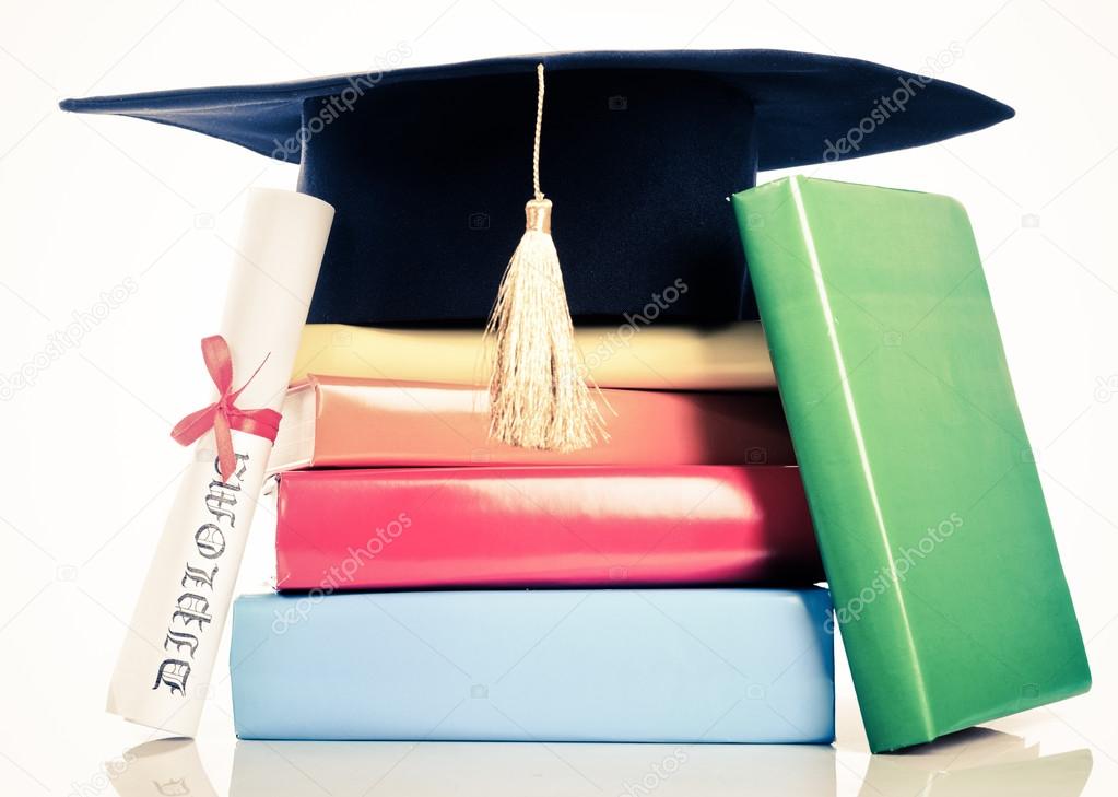 A mortarboard and graduation scroll on books