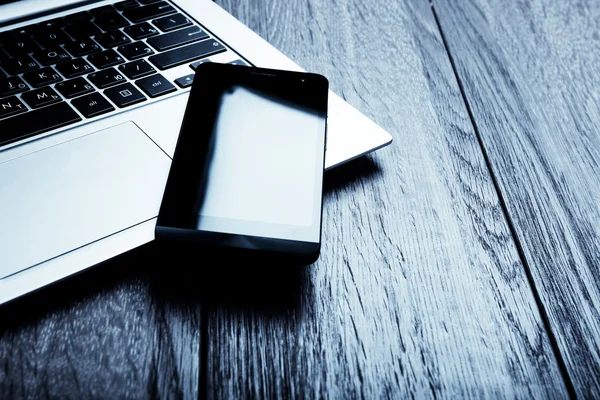 Keyboard with phone on wooden desk — Stock Photo, Image