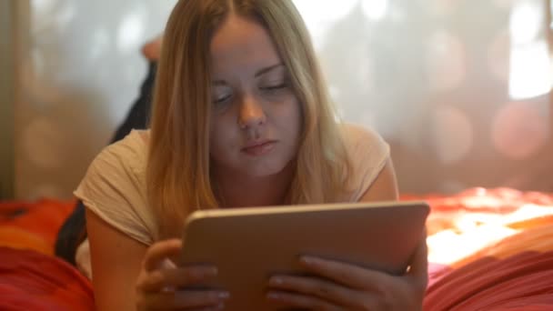 Femme utilisant une tablette couchée sur son lit — Video