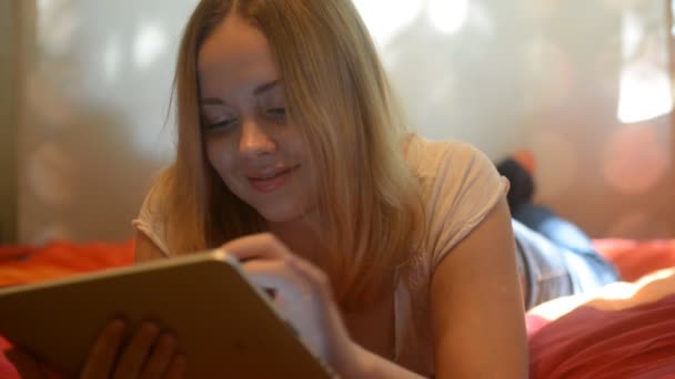 Woman using tablet lying on her bed — Αρχείο Βίντεο