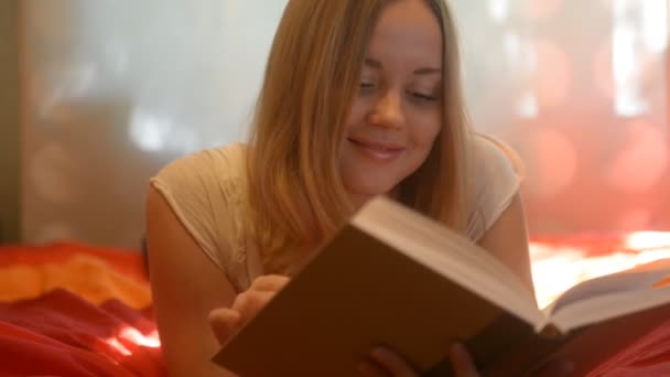 Mulher deitada na cama e livro de leitura — Vídeo de Stock