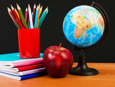 Küre, defter ve kalemler.