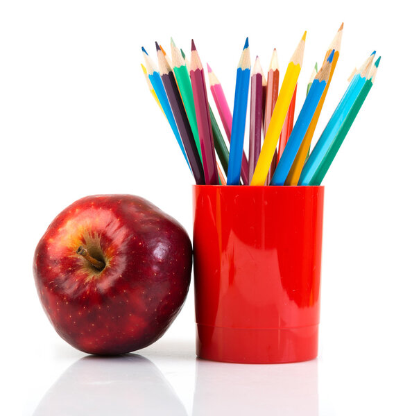 Pencils and apple on white