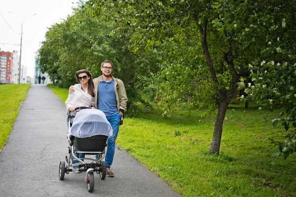 Man and woman with baby pram — Stock Photo, Image
