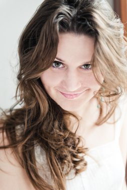 uzun kıvırcık saçlı gülümseyen kadın