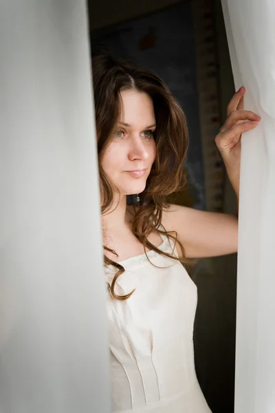 Serious woman looking at the window — Stock Photo, Image