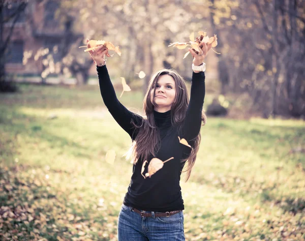 Femme jetant des feuilles femme dans la forêt — Photo