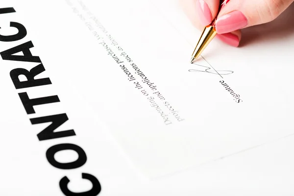 Mão feminina assinando um contrato — Fotografia de Stock