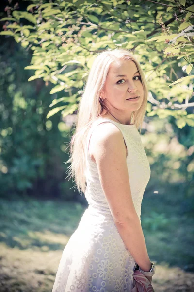 Blond woman in a white dress outdoors — Stock Photo, Image