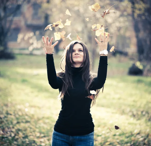 Mujer lanzando hojas mujer en el bosque —  Fotos de Stock
