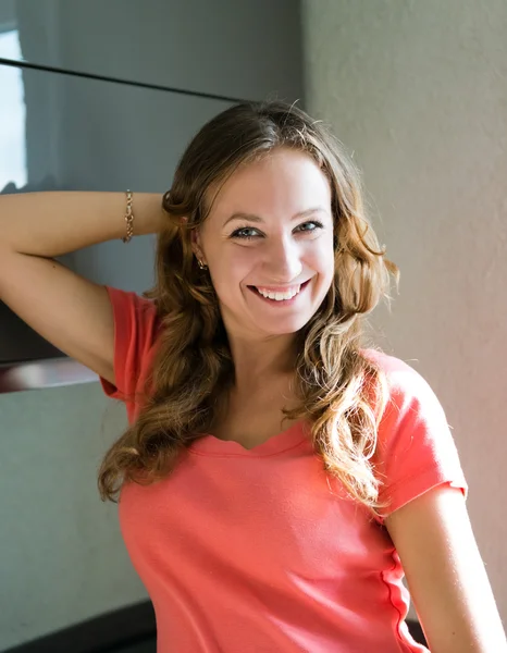 Woman standing against kitchen background — Stock Photo, Image