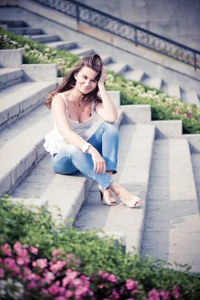 Beautiful european woman sitting on steps — Stock Photo, Image