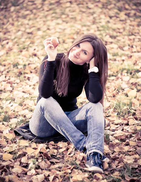 Jeune femme avec pomme dans le parc d'automne — Photo
