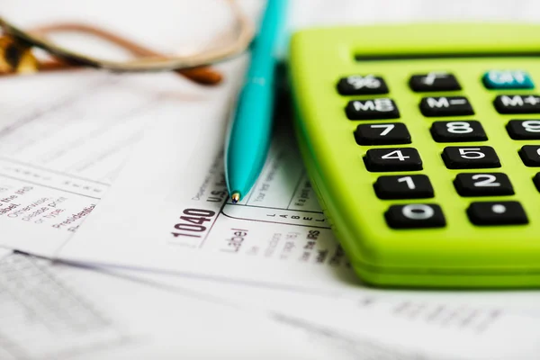 Налоговая форма, очки, ручка и калькулятор — стоковое фото