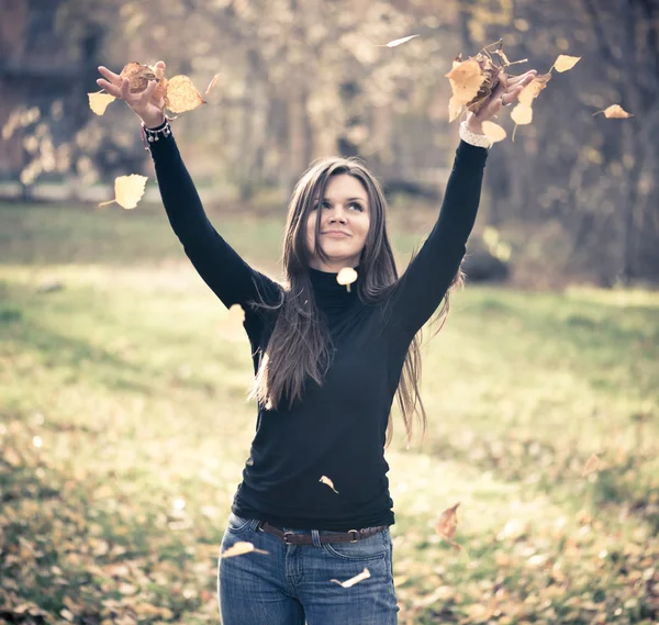 Mulher jogando folhas mulher na floresta — Fotografia de Stock