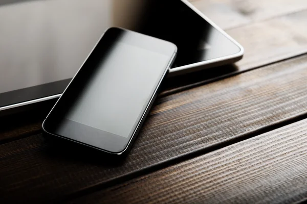 Toetsenbord met telefoon op houten bureau — Stockfoto