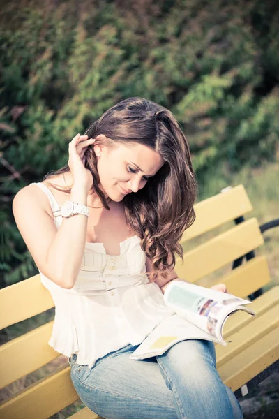 Frau liest im Park eine Zeitschrift — Stockfoto