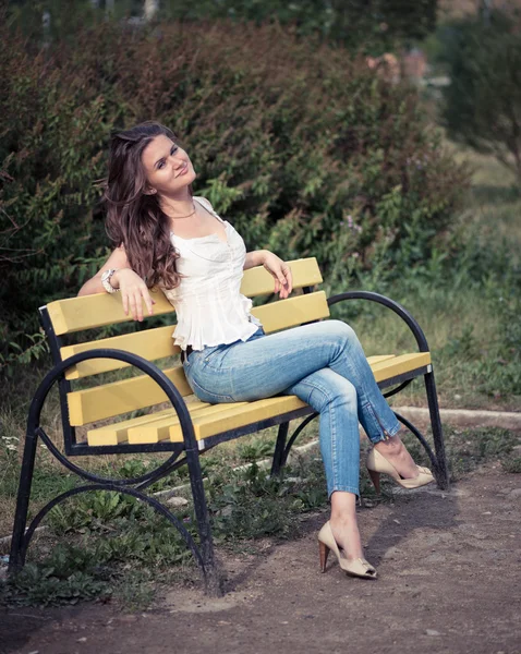 Femme assise sur un banc dans le parc — Photo