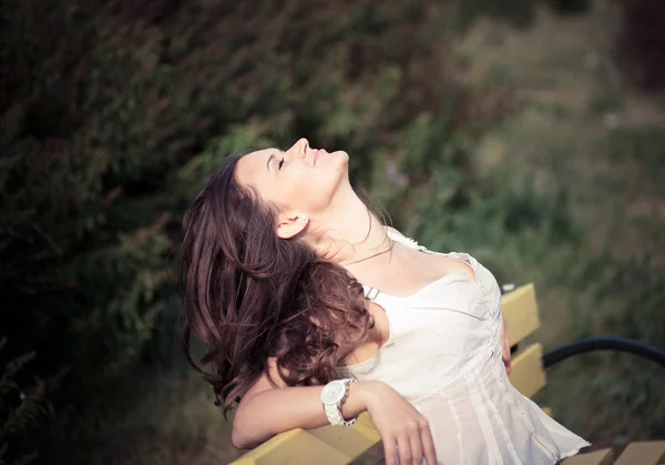 Woman relaxing on the bench in park — Stock Photo, Image